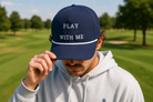 Man wearing navy 'Play Golf With Me' rope cap outdoors on a golf course